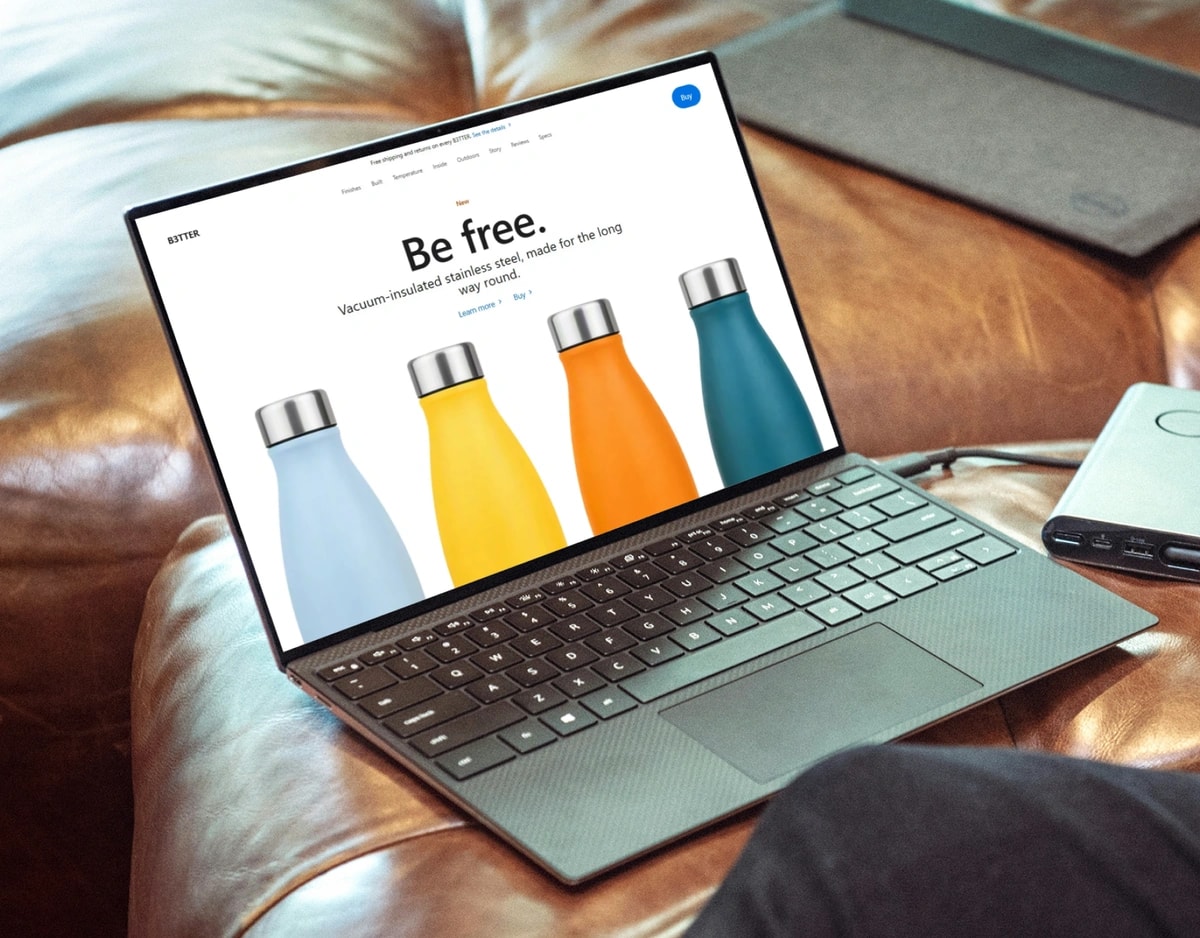 The B3TTER site open on a laptop resting on a leather couch